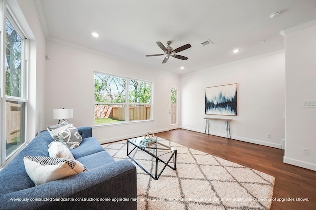 living room featuring a wealth of natural light, crown molding, ceiling fan, and dark wood-type flooring