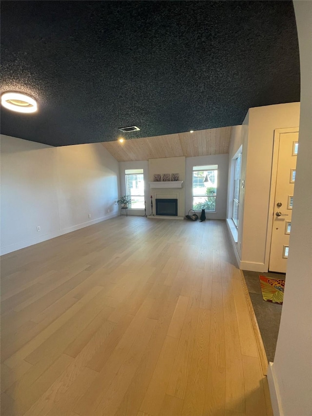 unfurnished living room with hardwood / wood-style floors and lofted ceiling