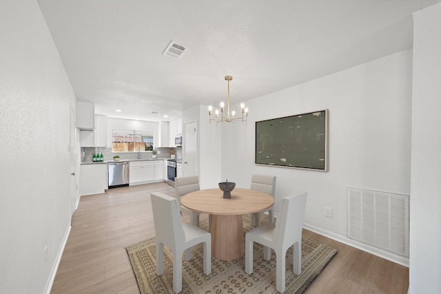 dining area featuring light hardwood / wood-style flooring and a chandelier