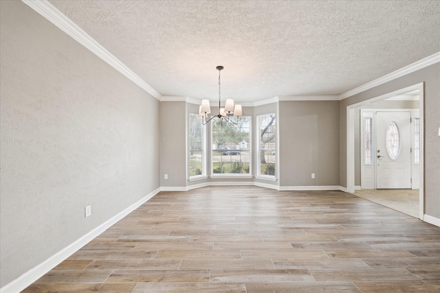 unfurnished dining area featuring crown molding, a textured ceiling, and an inviting chandelier