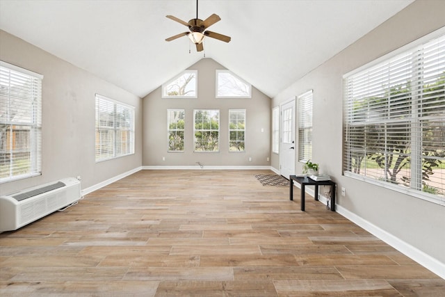 unfurnished sunroom featuring ceiling fan, vaulted ceiling, and an AC wall unit