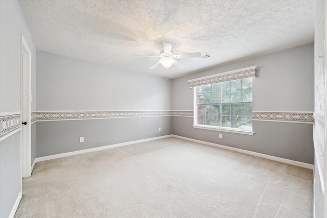 carpeted spare room with ceiling fan and a textured ceiling