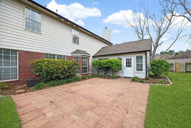 rear view of house with a lawn and a patio