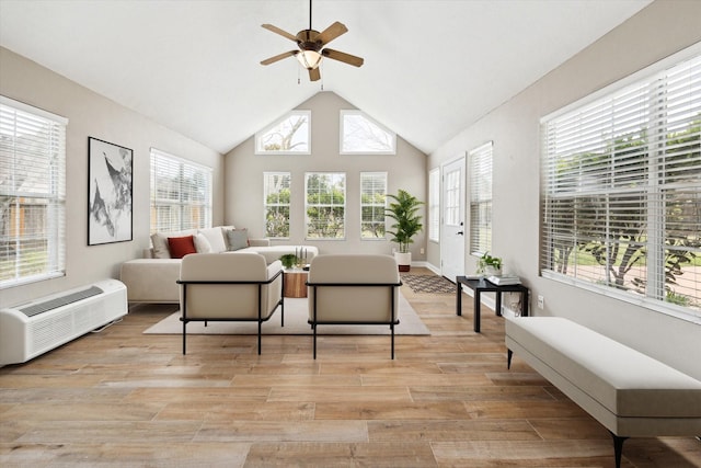 interior space featuring ceiling fan, lofted ceiling, a wall mounted AC, and light hardwood / wood-style floors