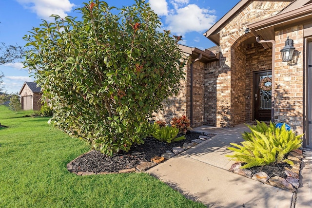 view of exterior entry featuring a lawn