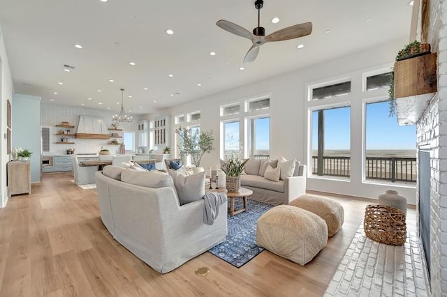 living room featuring ceiling fan, a healthy amount of sunlight, and light wood-type flooring