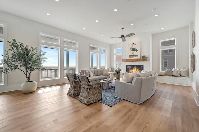 living room featuring light wood-type flooring and ceiling fan