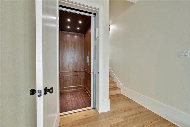 hall featuring elevator and light hardwood / wood-style flooring