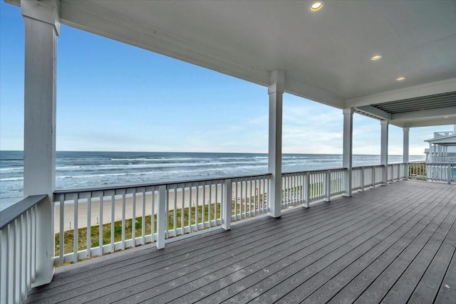 deck featuring a view of the beach and a water view