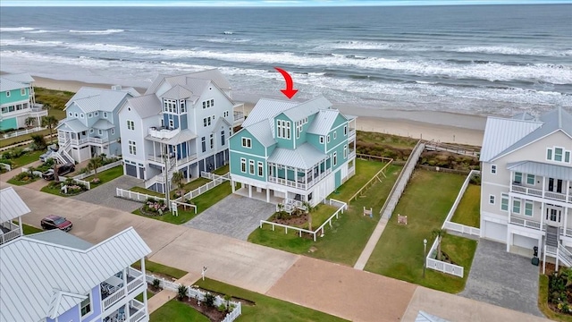 drone / aerial view featuring a water view and a beach view