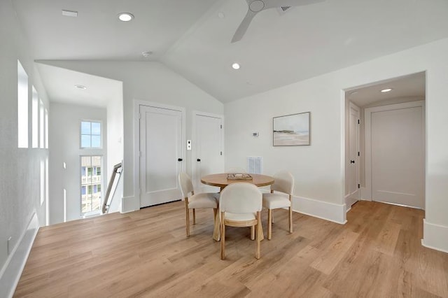 dining space featuring light wood-type flooring, vaulted ceiling, and ceiling fan