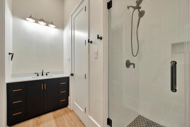 bathroom with wood-type flooring, vanity, and walk in shower