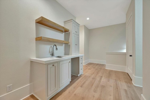 bar featuring light hardwood / wood-style floors and sink