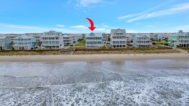 view of building exterior with a beach view and a water view