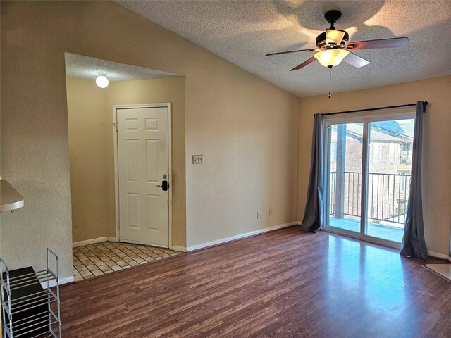 spare room featuring hardwood / wood-style floors, a textured ceiling, ceiling fan, and lofted ceiling