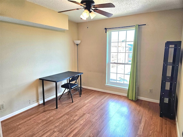 office space featuring hardwood / wood-style flooring, ceiling fan, and a textured ceiling