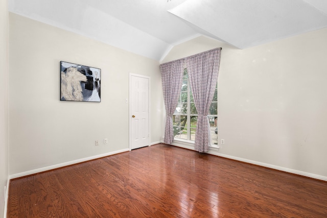 empty room featuring hardwood / wood-style floors and vaulted ceiling