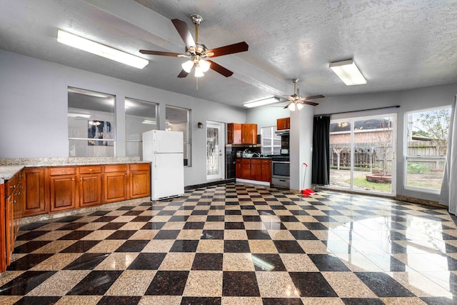 kitchen featuring a textured ceiling, white refrigerator, vaulted ceiling, and stainless steel stove