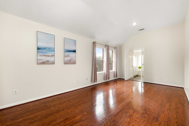 unfurnished room with hardwood / wood-style flooring and vaulted ceiling