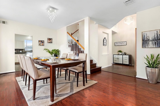 dining area with dark wood-type flooring and a chandelier