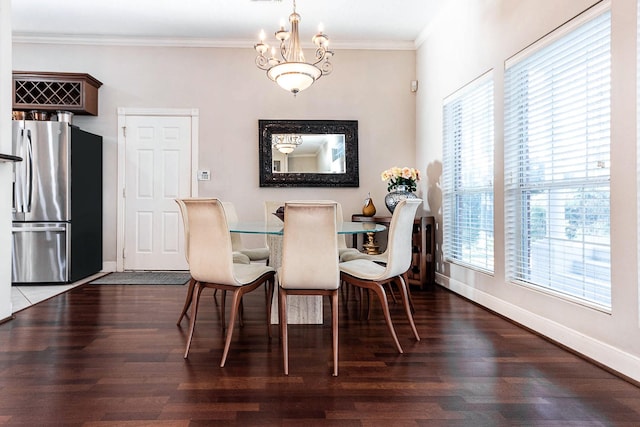 dining room featuring wood-type flooring, a notable chandelier, and ornamental molding