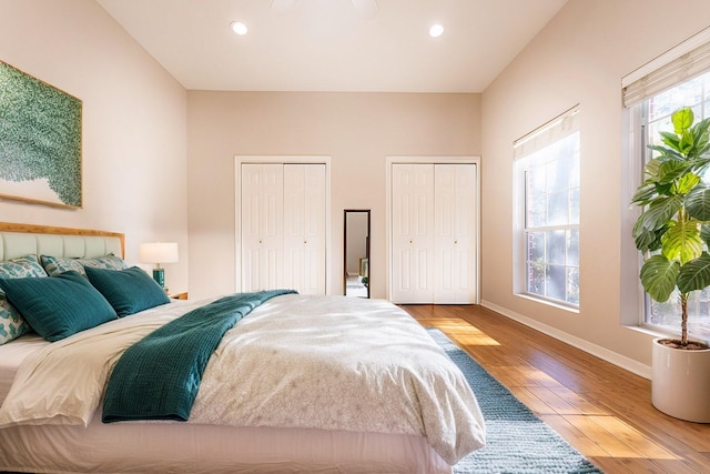 bedroom with multiple closets, multiple windows, and hardwood / wood-style flooring