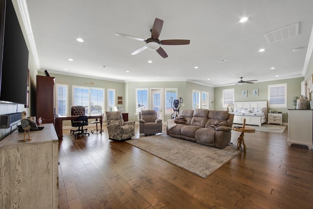 living room with ornamental molding, visible vents, ceiling fan, and dark wood-style floors