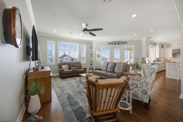 living room featuring a ceiling fan, visible vents, crown molding, and dark wood-style floors