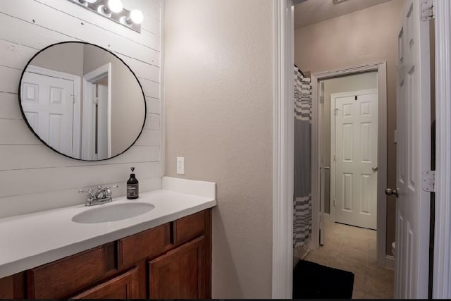 bathroom featuring vanity and wood walls