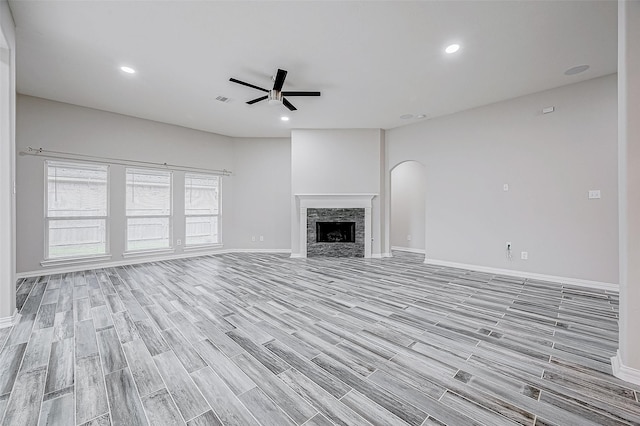 unfurnished living room with a fireplace, light wood-type flooring, and ceiling fan