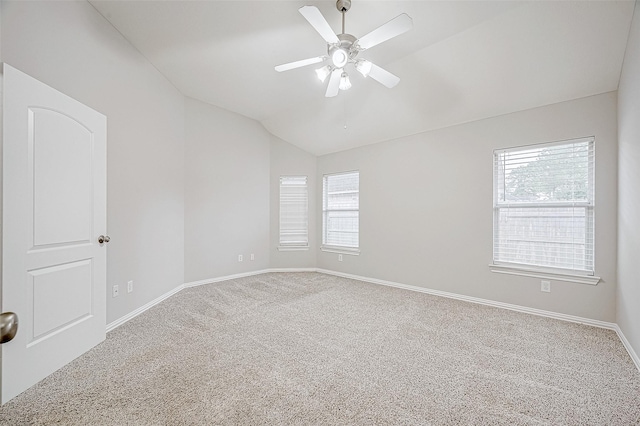 carpeted empty room featuring vaulted ceiling, ceiling fan, and a healthy amount of sunlight