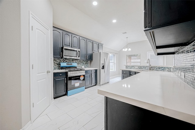 kitchen featuring decorative light fixtures, vaulted ceiling, kitchen peninsula, backsplash, and appliances with stainless steel finishes