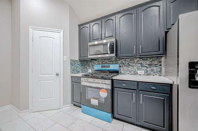 kitchen featuring stainless steel appliances, vaulted ceiling, tasteful backsplash, and gray cabinets