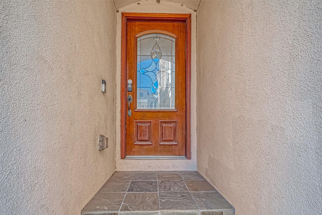 doorway to property featuring stucco siding