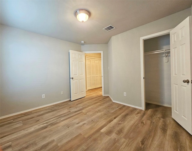 unfurnished bedroom with light hardwood / wood-style floors and a closet