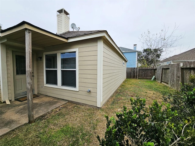 view of property exterior with a yard and a patio area