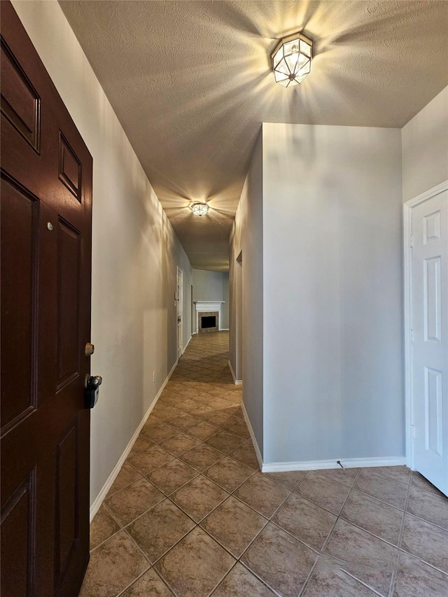 hallway with light tile patterned floors and a textured ceiling