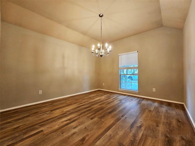 empty room featuring an inviting chandelier, vaulted ceiling, and dark wood-type flooring