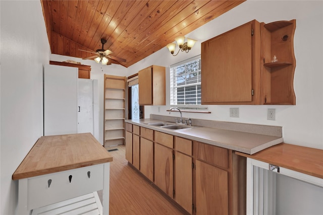 kitchen featuring ceiling fan with notable chandelier, light hardwood / wood-style flooring, lofted ceiling, and sink