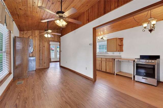 kitchen featuring light wood-type flooring, ceiling fan with notable chandelier, stainless steel electric stove, hanging light fixtures, and lofted ceiling