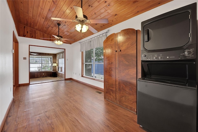 kitchen with wood ceiling, vaulted ceiling, ceiling fan, hardwood / wood-style flooring, and stacked washer / drying machine