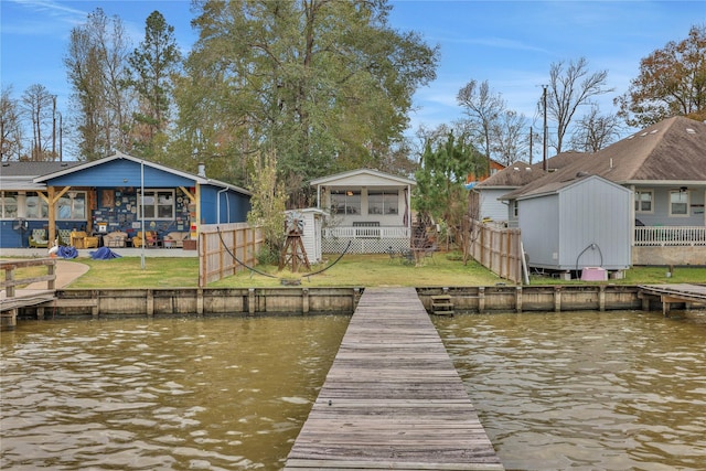 view of dock featuring a water view and a lawn