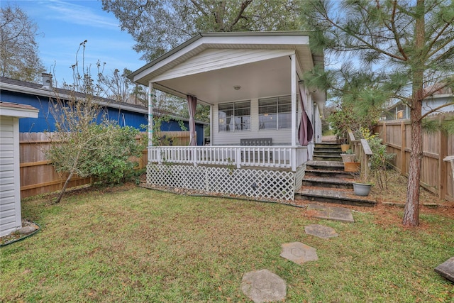 back of house featuring a lawn and a deck