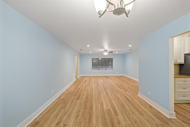 unfurnished living room with light hardwood / wood-style floors and ceiling fan with notable chandelier