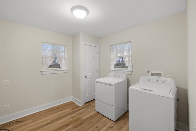 laundry room with washing machine and clothes dryer, light hardwood / wood-style floors, and plenty of natural light