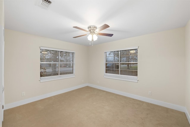 carpeted spare room featuring ceiling fan