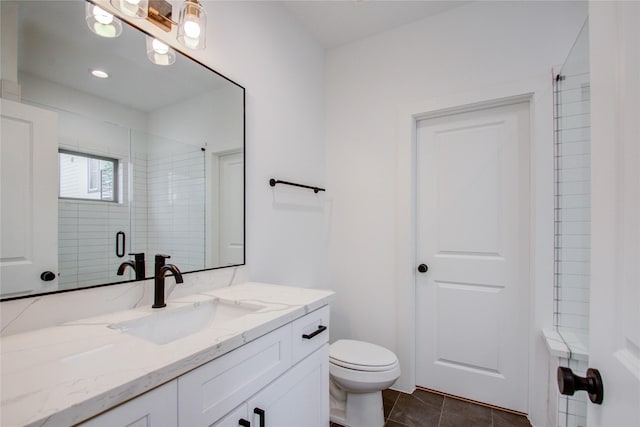 bathroom with toilet, vanity, a shower with door, and tile patterned flooring