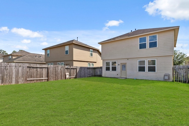 rear view of house featuring a lawn