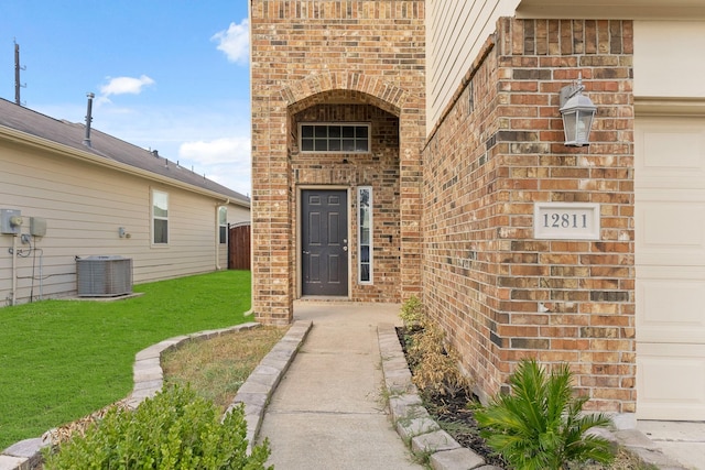 doorway to property with central AC and a yard