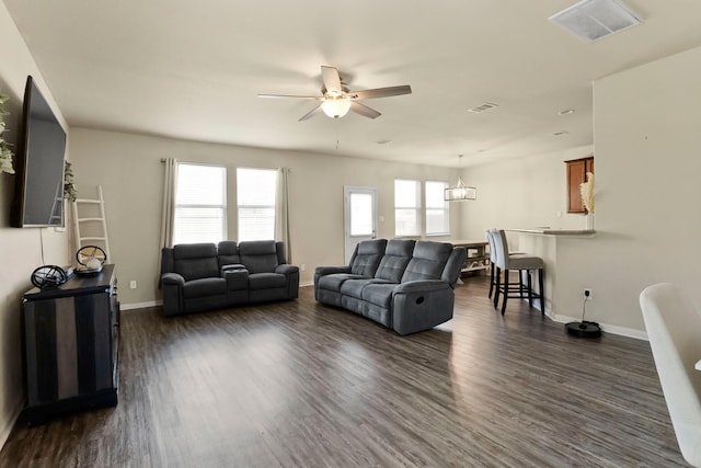 living room featuring dark hardwood / wood-style flooring and ceiling fan with notable chandelier